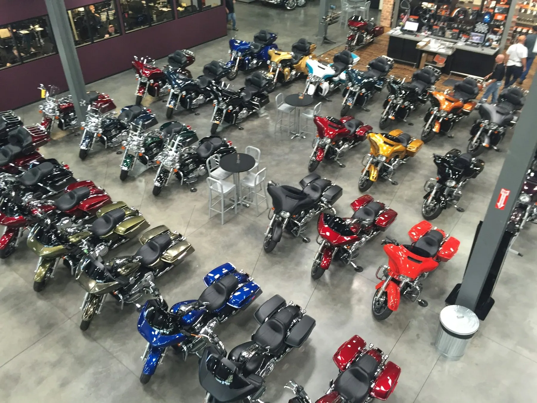 A large hall filled with new motorcycles arranged in rows on a tiled floor
