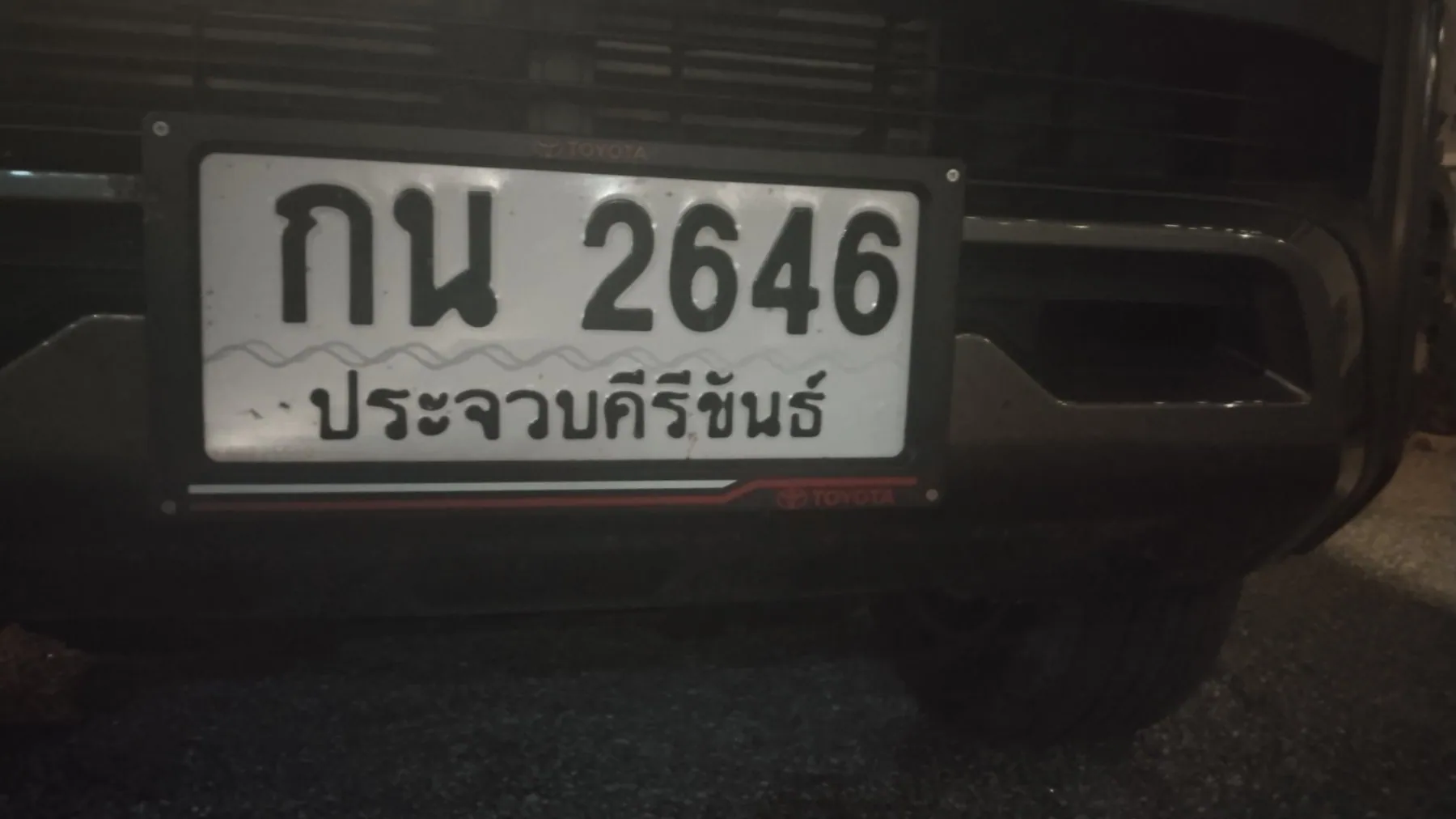 A white Thai number plate bolted to a car bumper reading กน 2646 with the province name ประจวบคีรีขันธ์ across the bottom