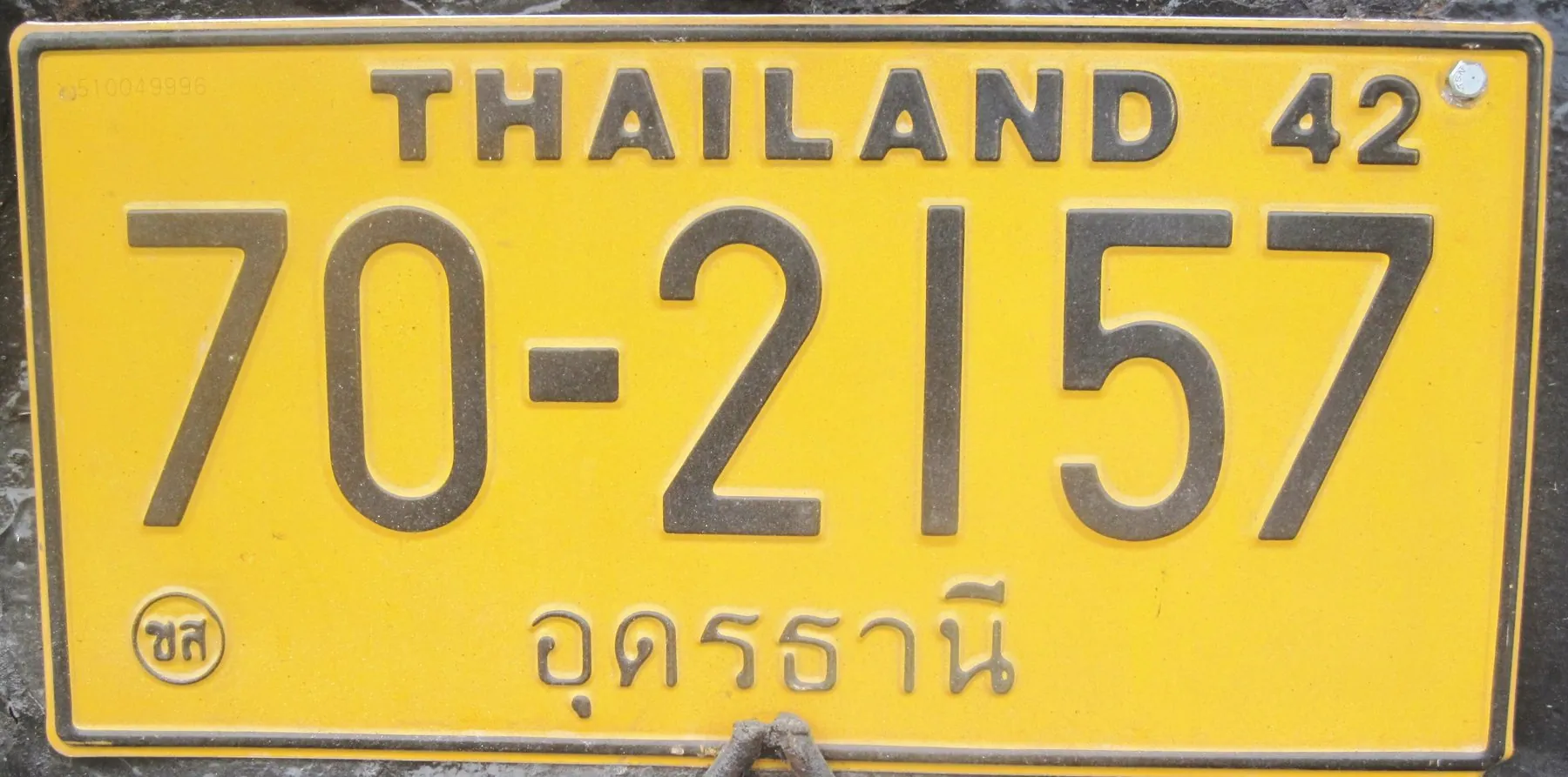 A yellow Thai number plate reading THAILAND above the registration number with the province in Thai script beneath