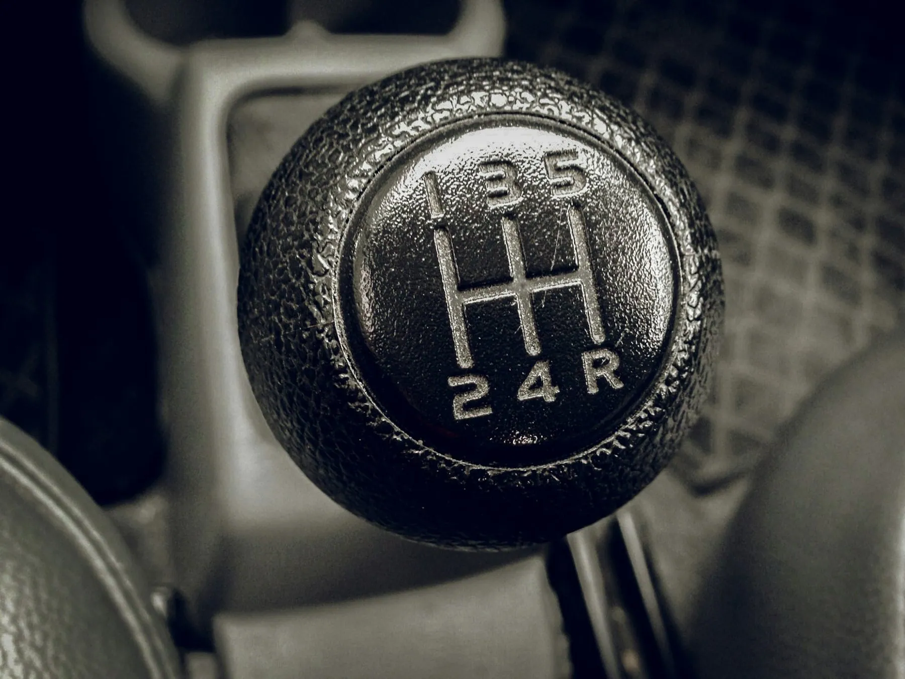 Close-up of a five-speed manual gear knob with the shift pattern moulded into the top