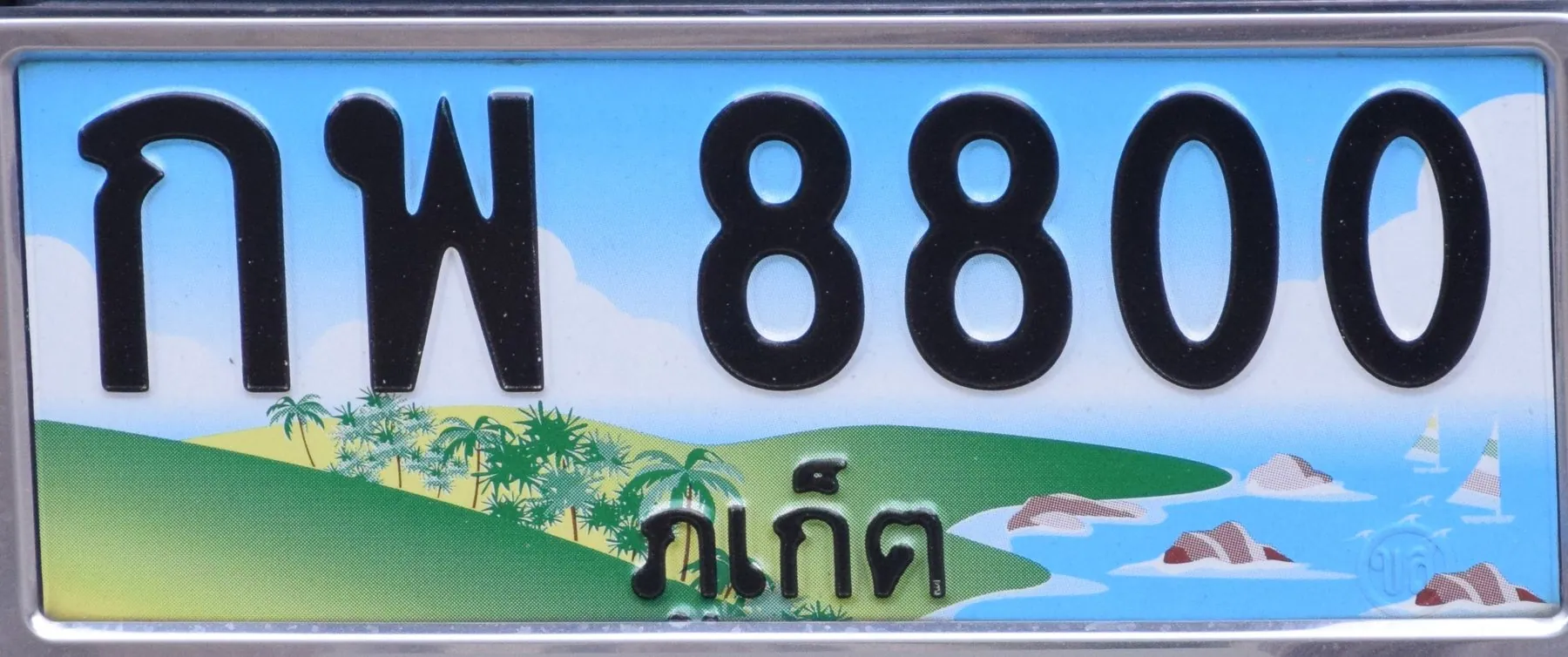 A Thai car number plate printed with a pale island-and-palms background and the province name in Thai