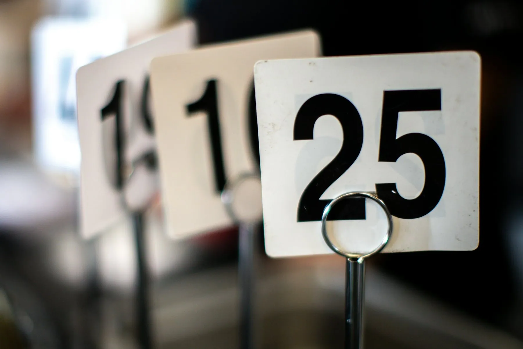 Numbered ticket stands in a row, the nearest reading 25