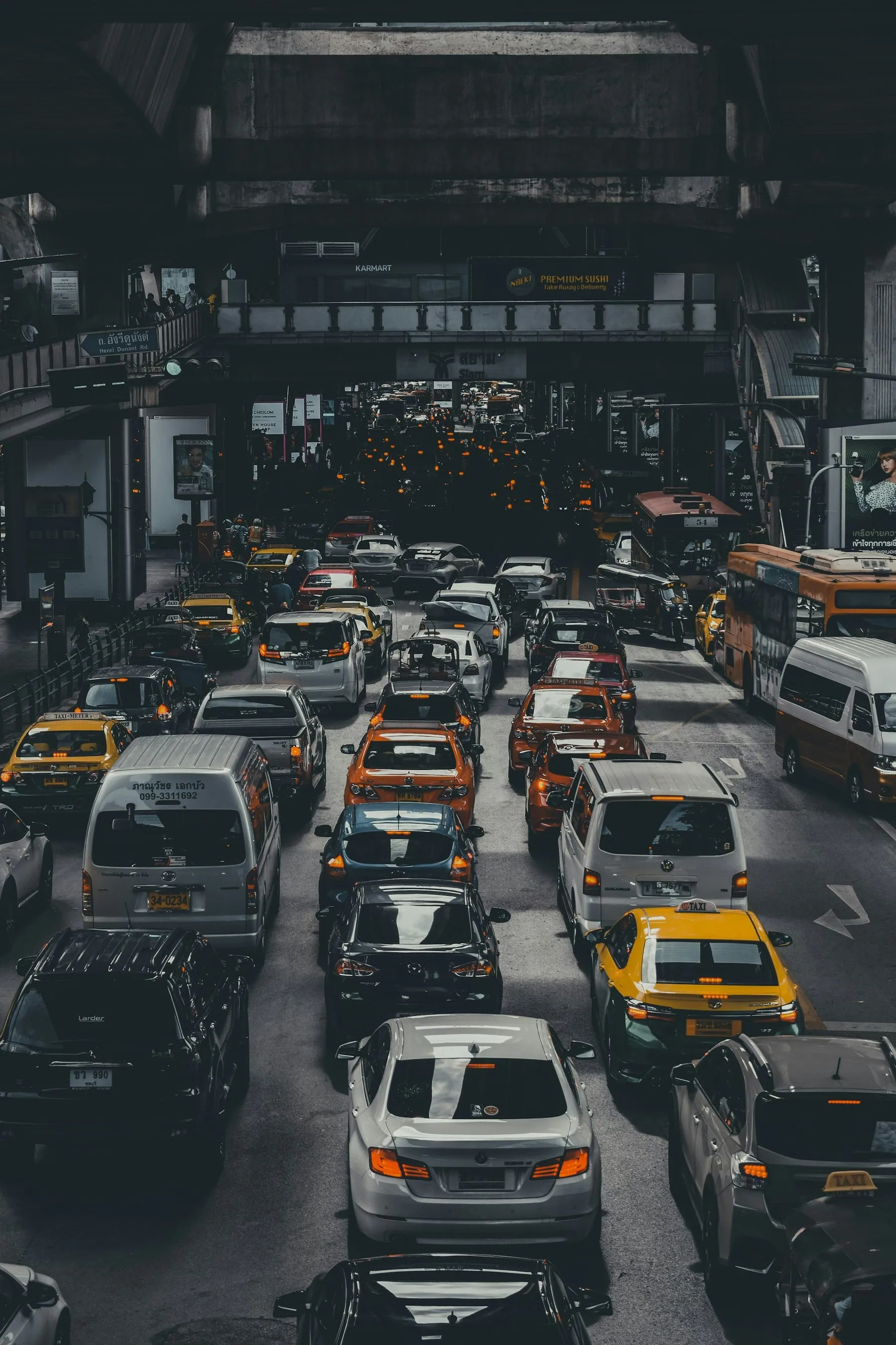 Cars, vans and motorbikes packed nose to tail in slow Bangkok traffic seen from above
