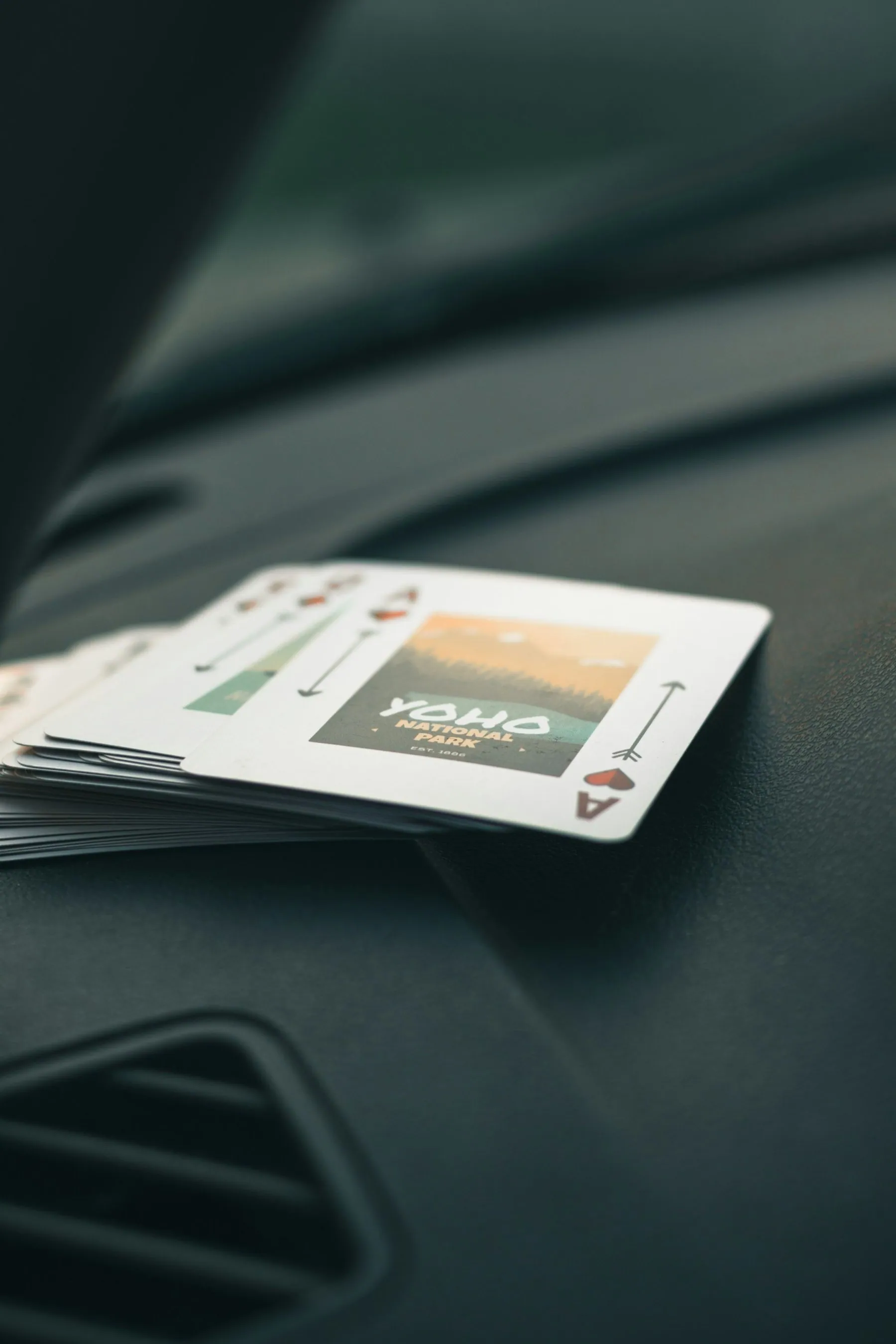 A pale identity card lying on the dark leather of a car dashboard