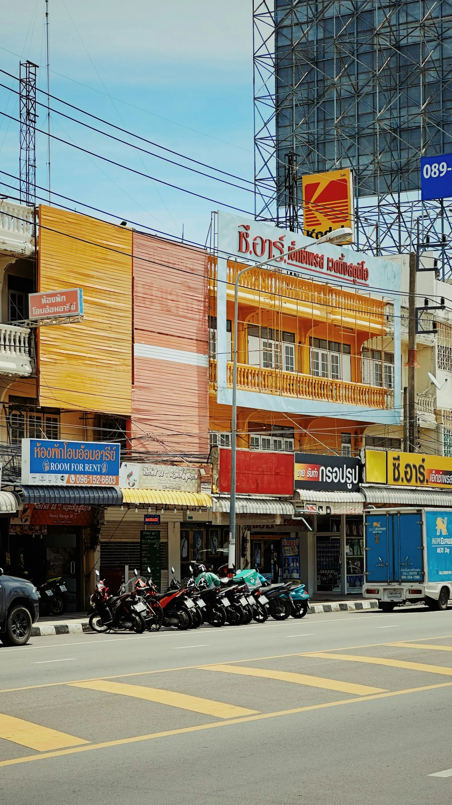 Motorbikes parked outside Thai shophouses on a Hua Hin street in the middle of the day