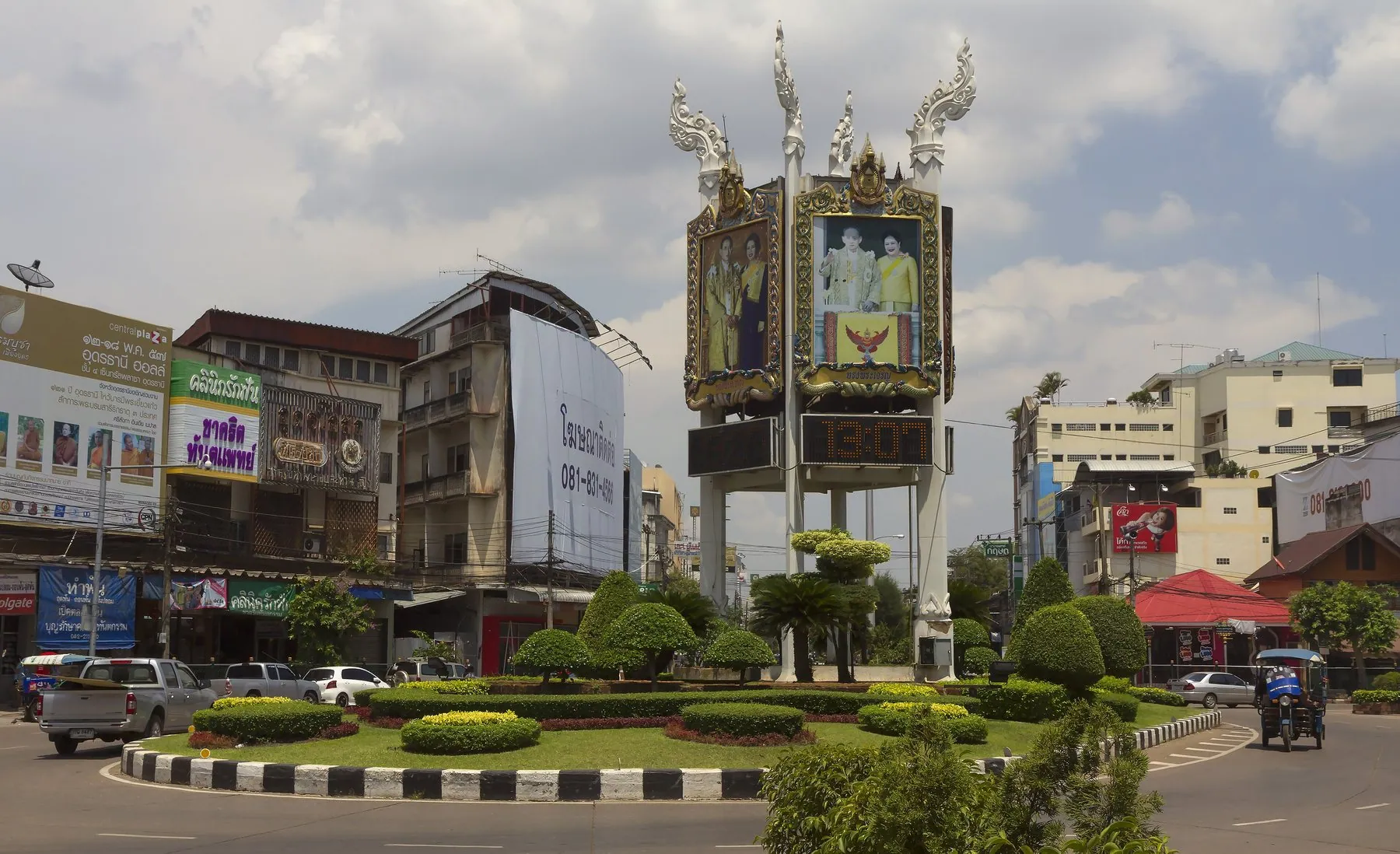 Cars and a tuk-tuk circling the planted clock roundabout in the centre of Udon Thani