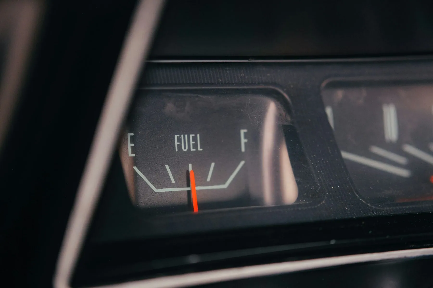 A car fuel gauge with the needle resting on empty