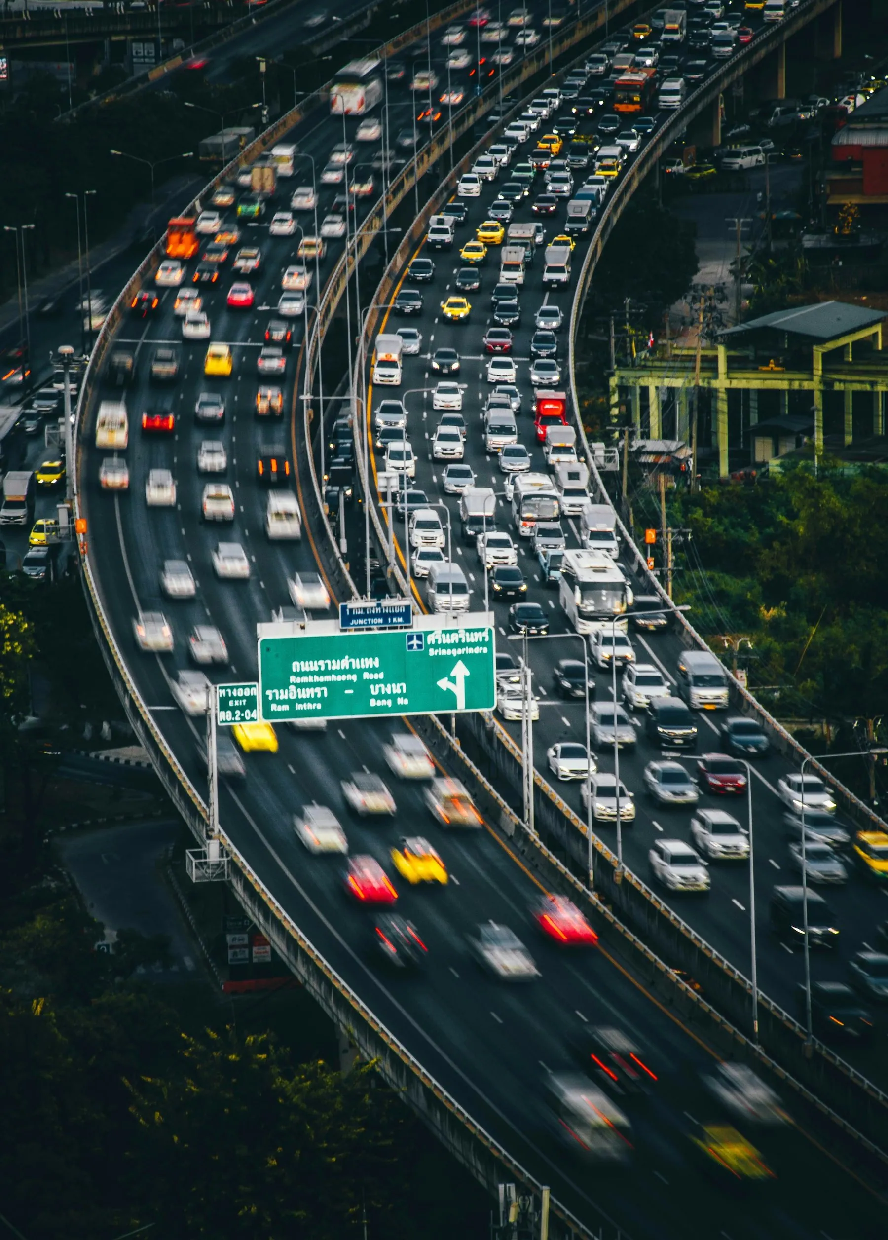 Traffic curving through a multi-level expressway interchange seen from above in Bangkok