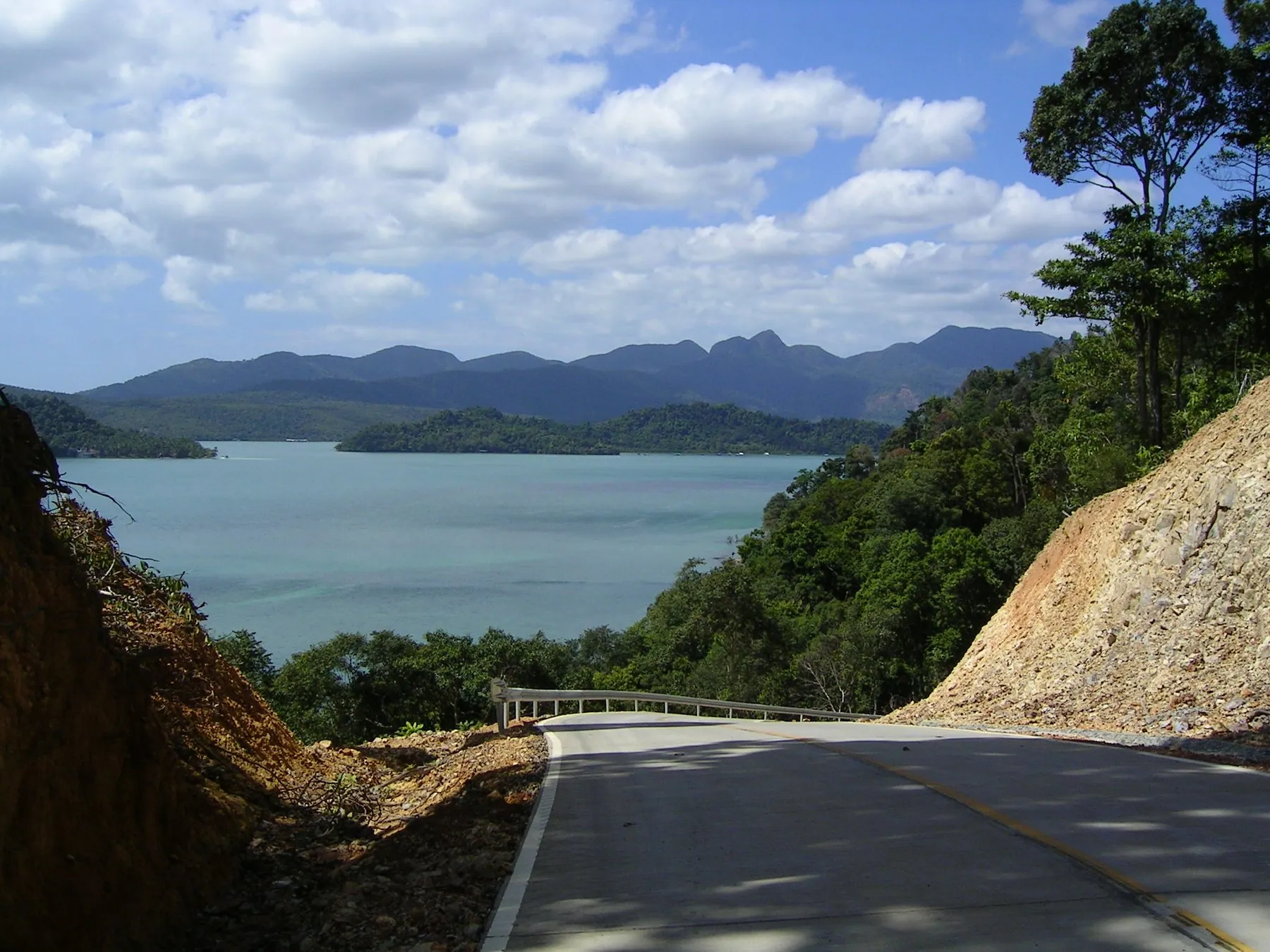 A steep road cut into the hillside on Koh Chang, dropping towards the bay at Ao Salak Phet