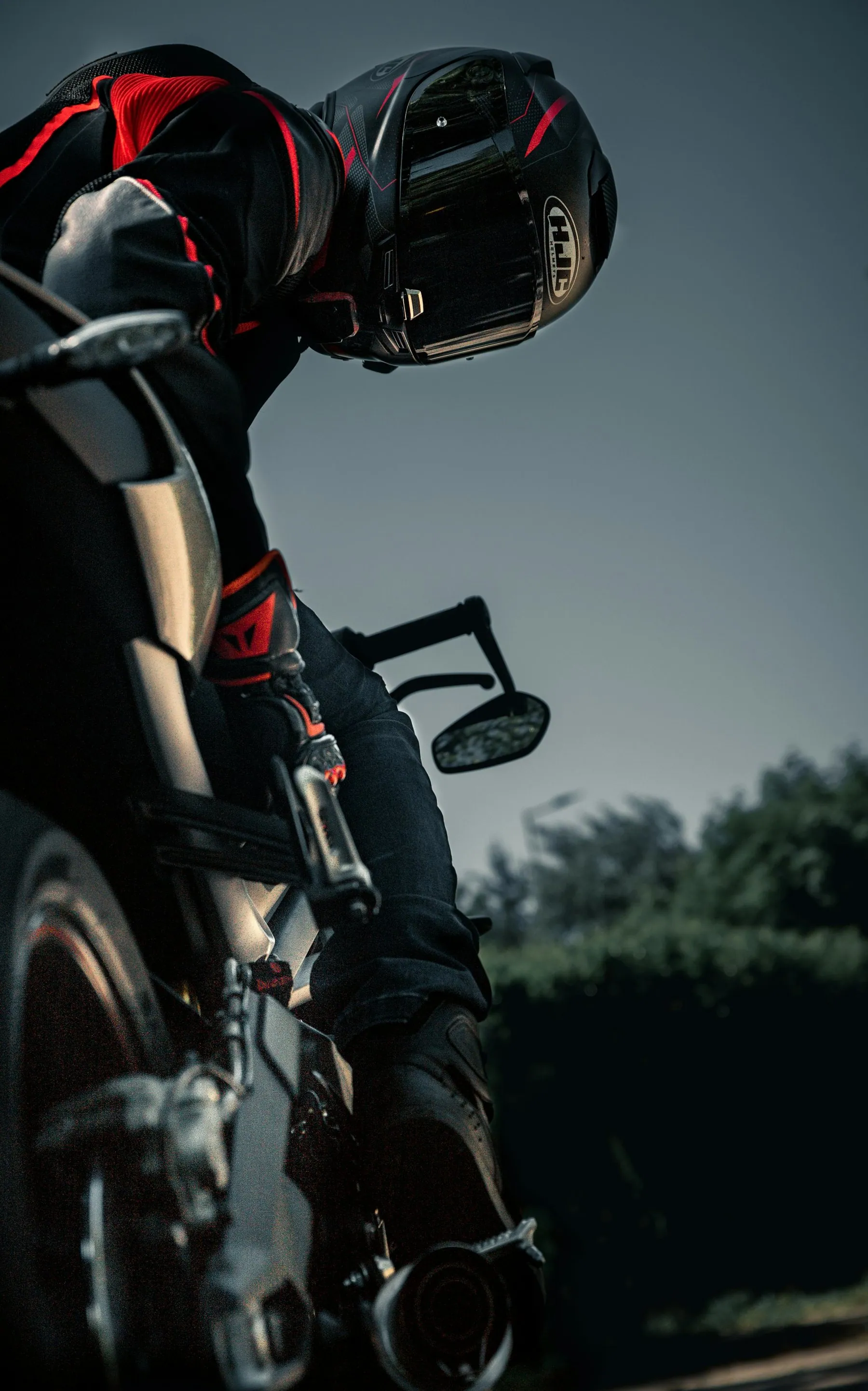 Two helmets hooked over the tail of a parked motorbike