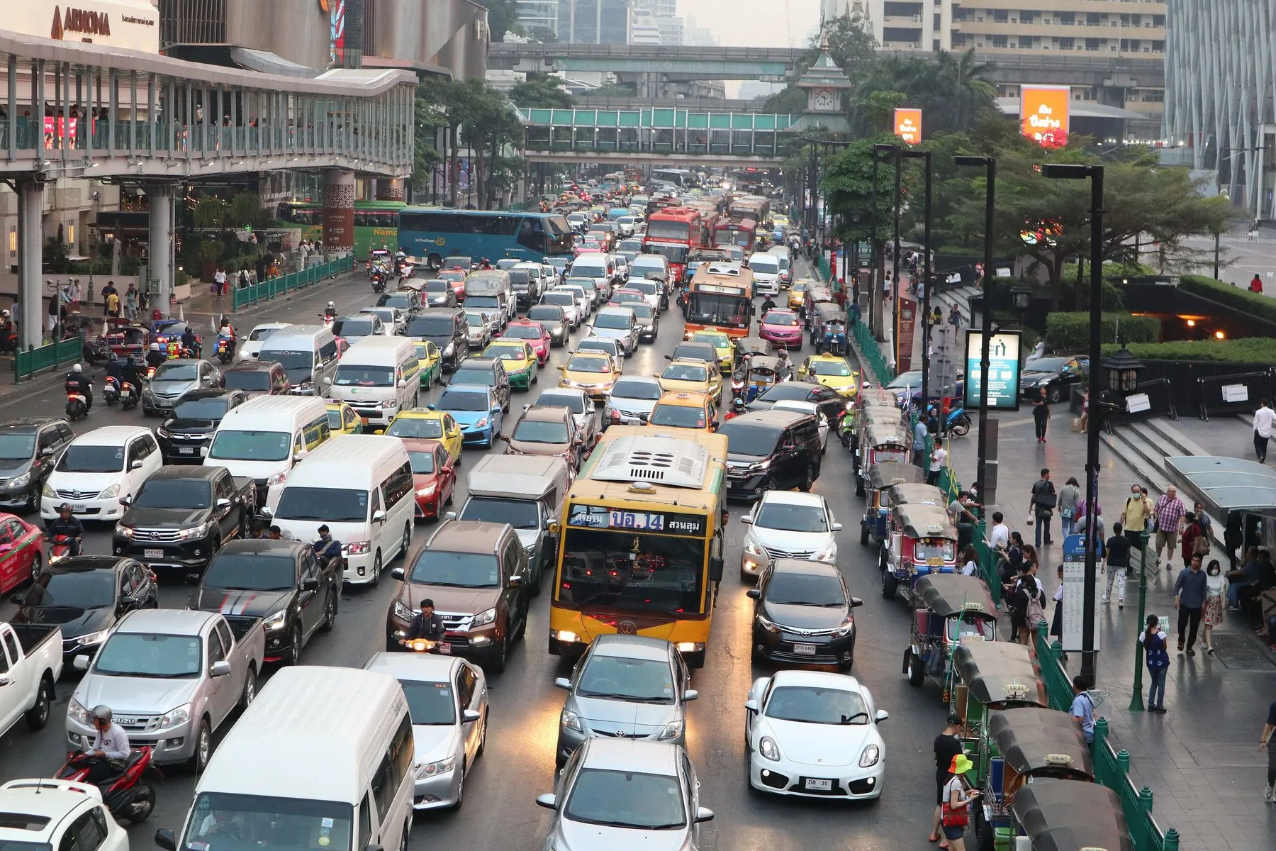 A downtown Bangkok street at a standstill during rush hour, seen from a footbridge above the lanes