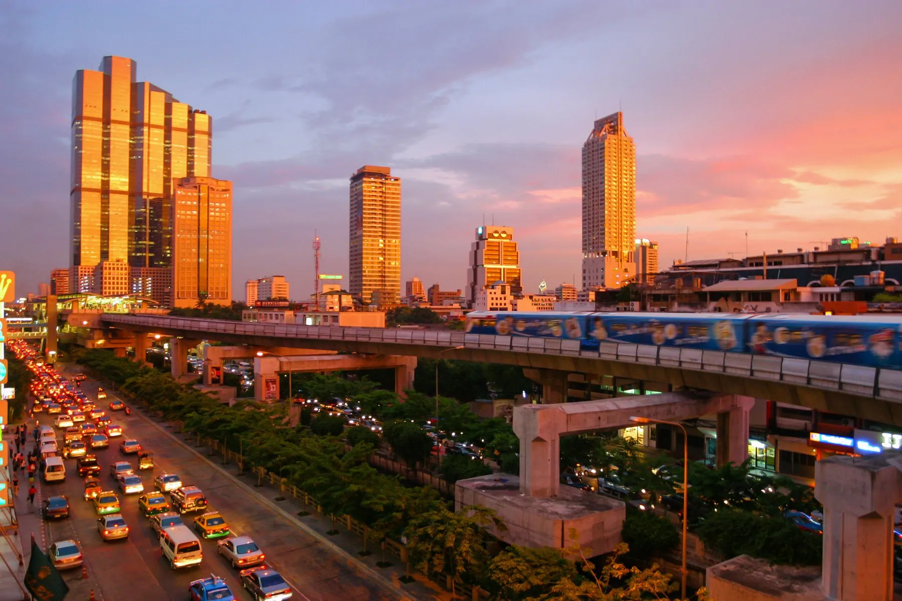 Traffic on Thanon Naradhiwas Rajanagarindra beneath the elevated Skytrain line in Bangkok at sunset