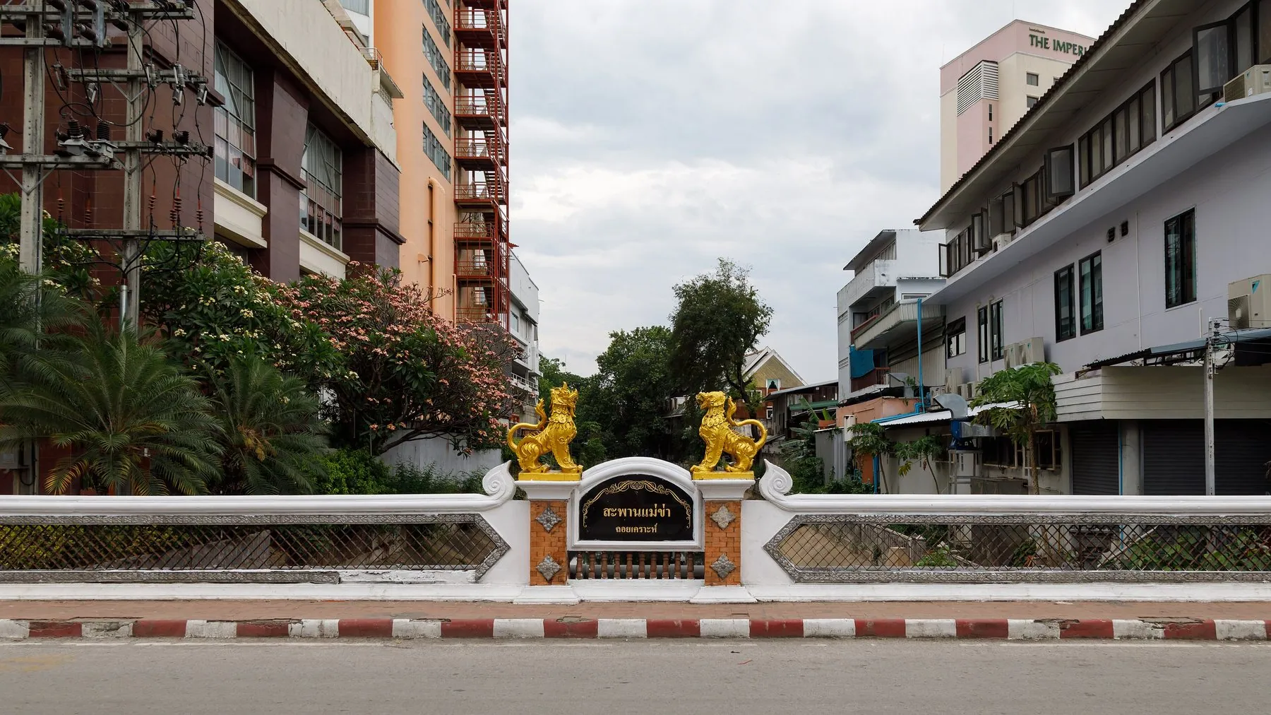 The bridge carrying Loi Kroh Road over the Chiang Mai moat, flanked by two gilded lion statues