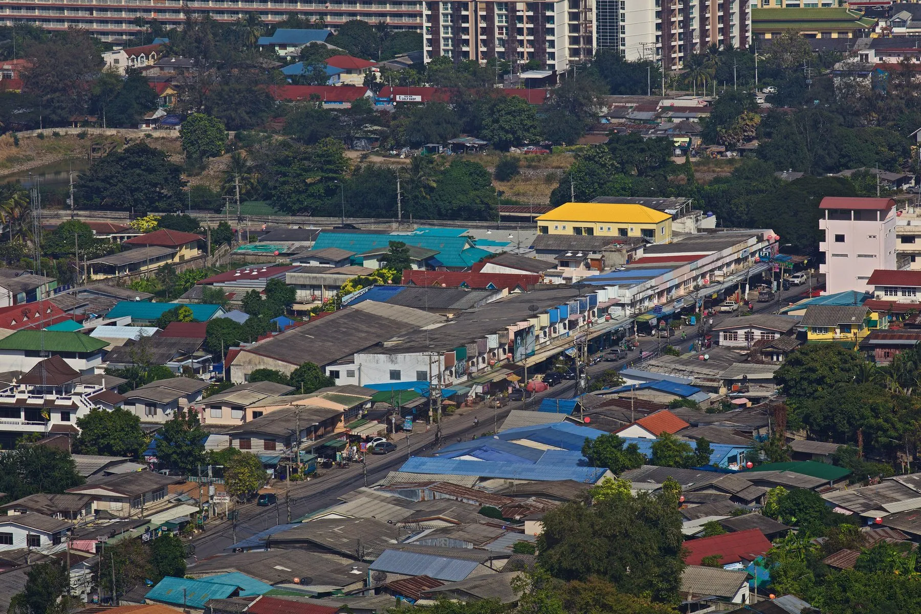 Hua Hin seen from above, low-rise streets and coloured roofs running back from the shore