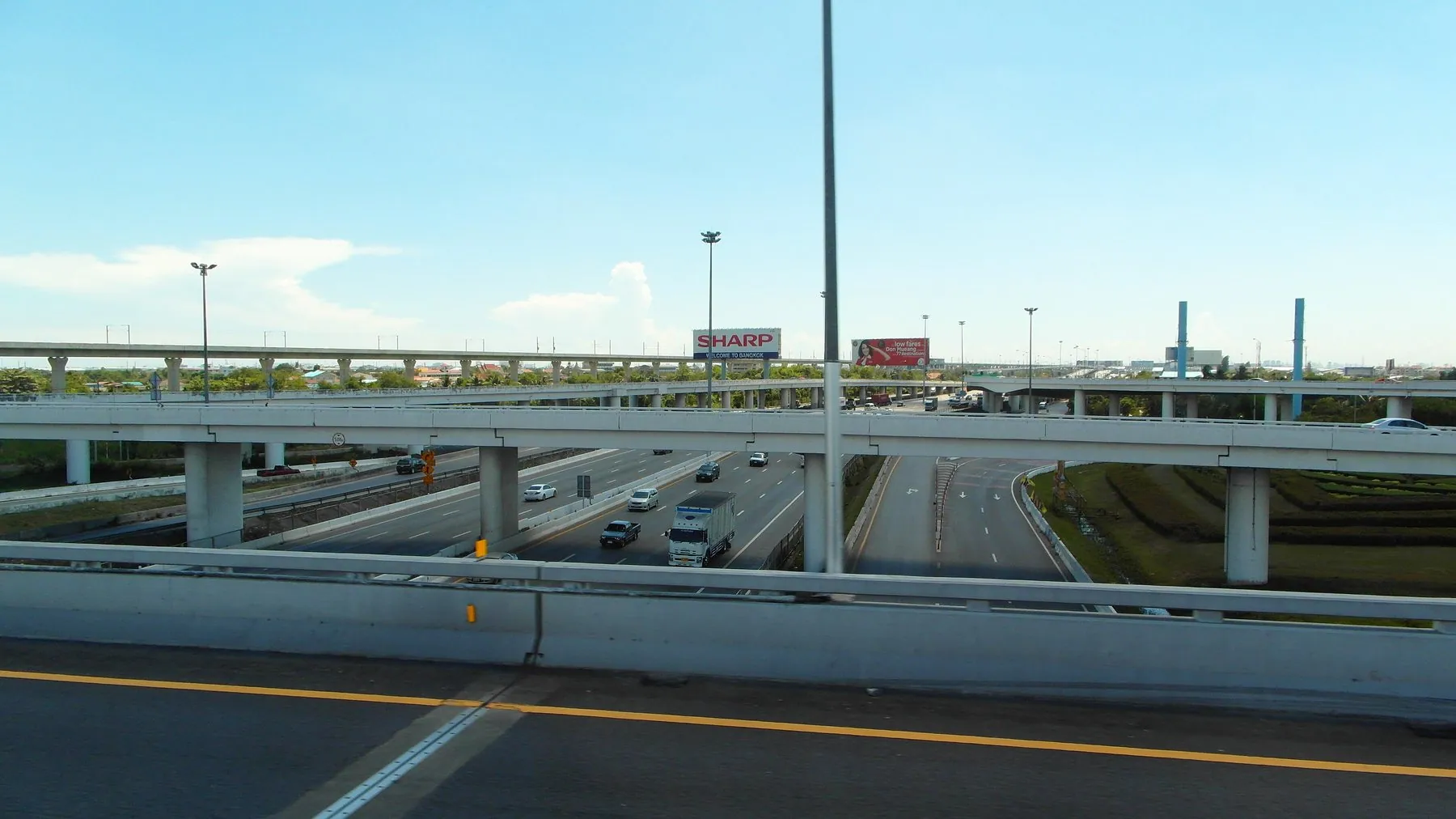 Slip roads peeling off a Bangkok expressway interchange towards a bank of toll lanes