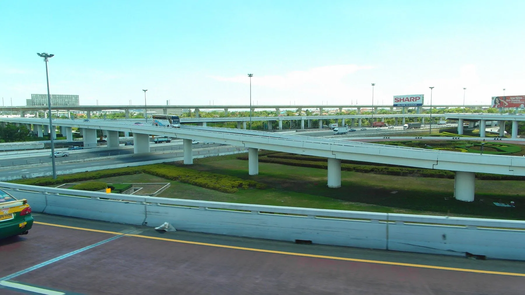 A multi-level Bangkok interchange with a line of toll gates spanning the carriageway below
