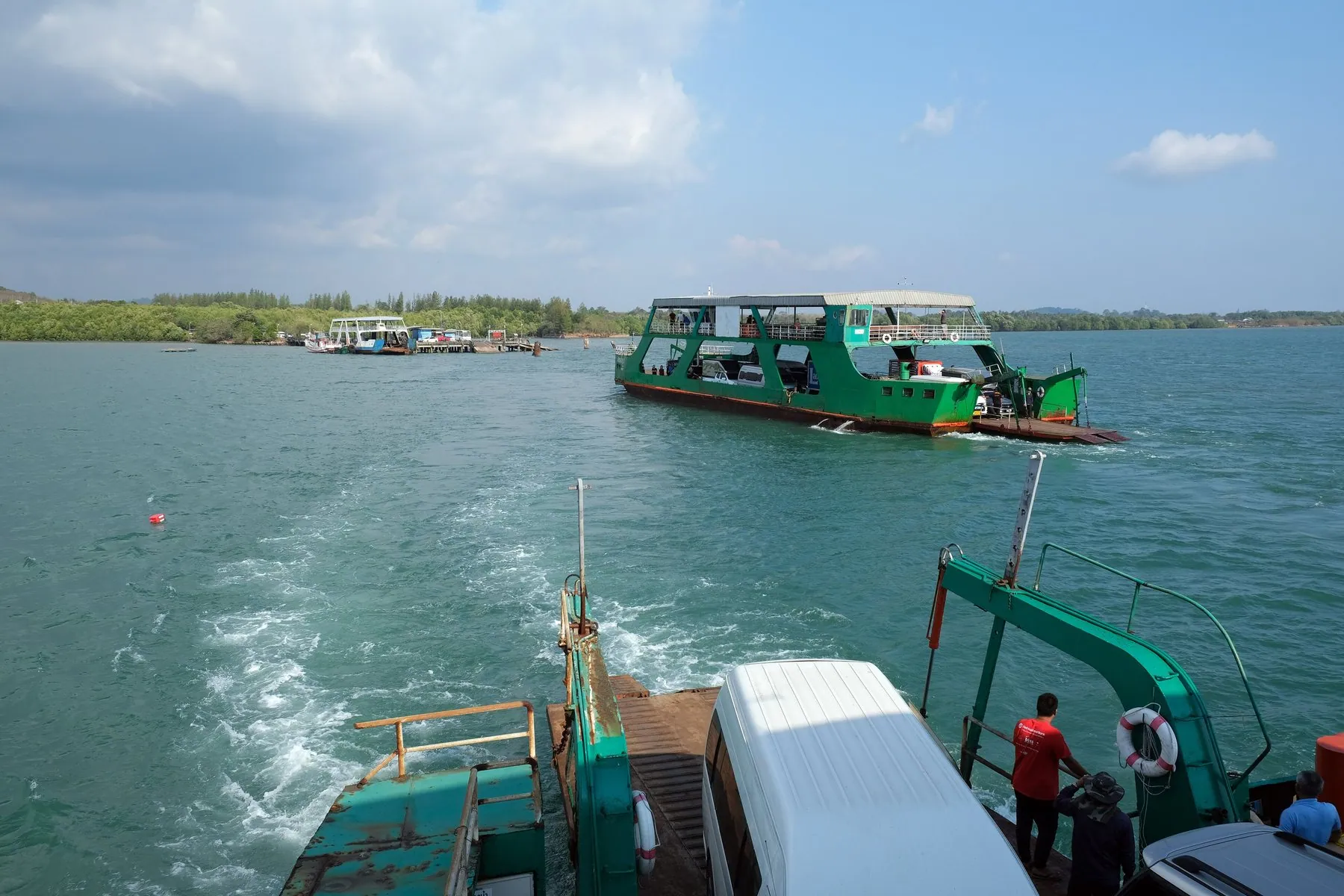 The stern of a loaded Koh Chang ferry with a lorry on deck and the green coast astern