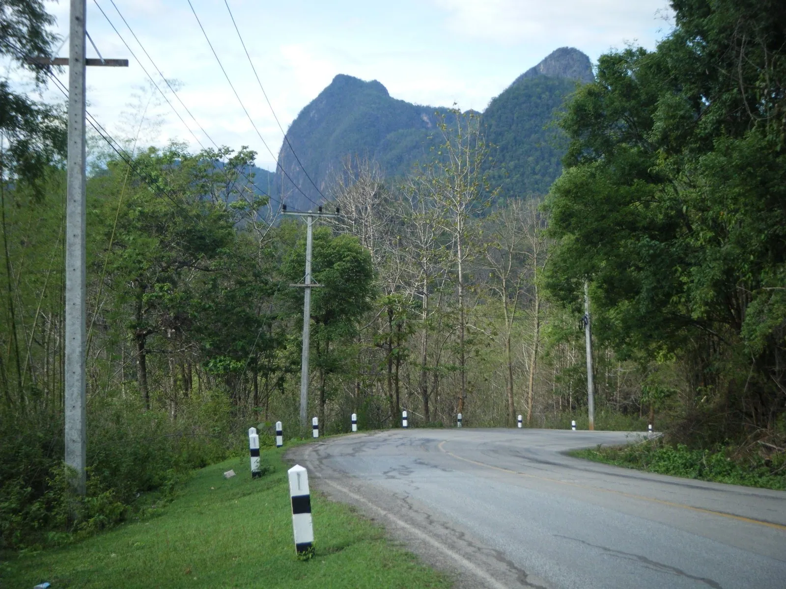 A quiet road running towards steep limestone hills in Mae Hong Son province