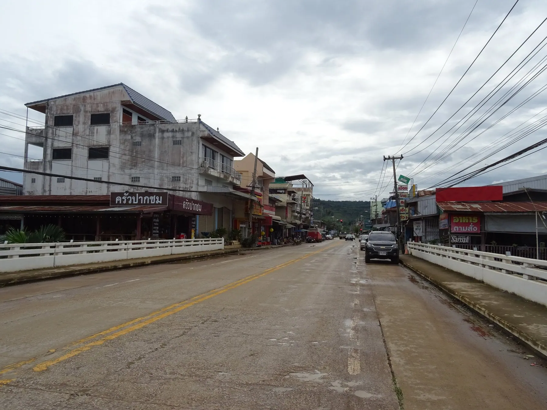 Route 211 running through Pak Chom on the Mekong, low shophouses and tangled overhead wires either side