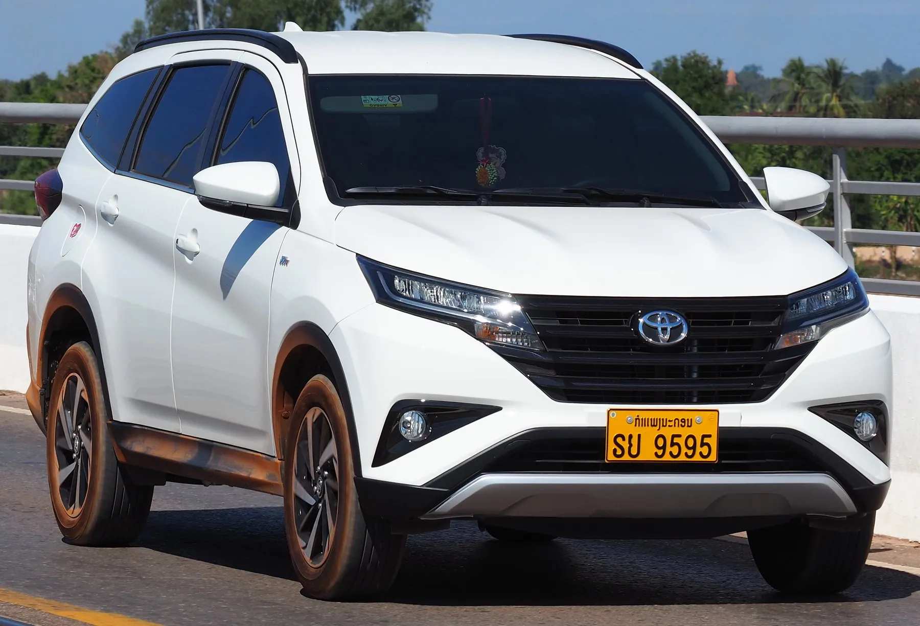A white Toyota SUV on Thai plates parked at the Thai-Lao Friendship Bridge in Nong Khai