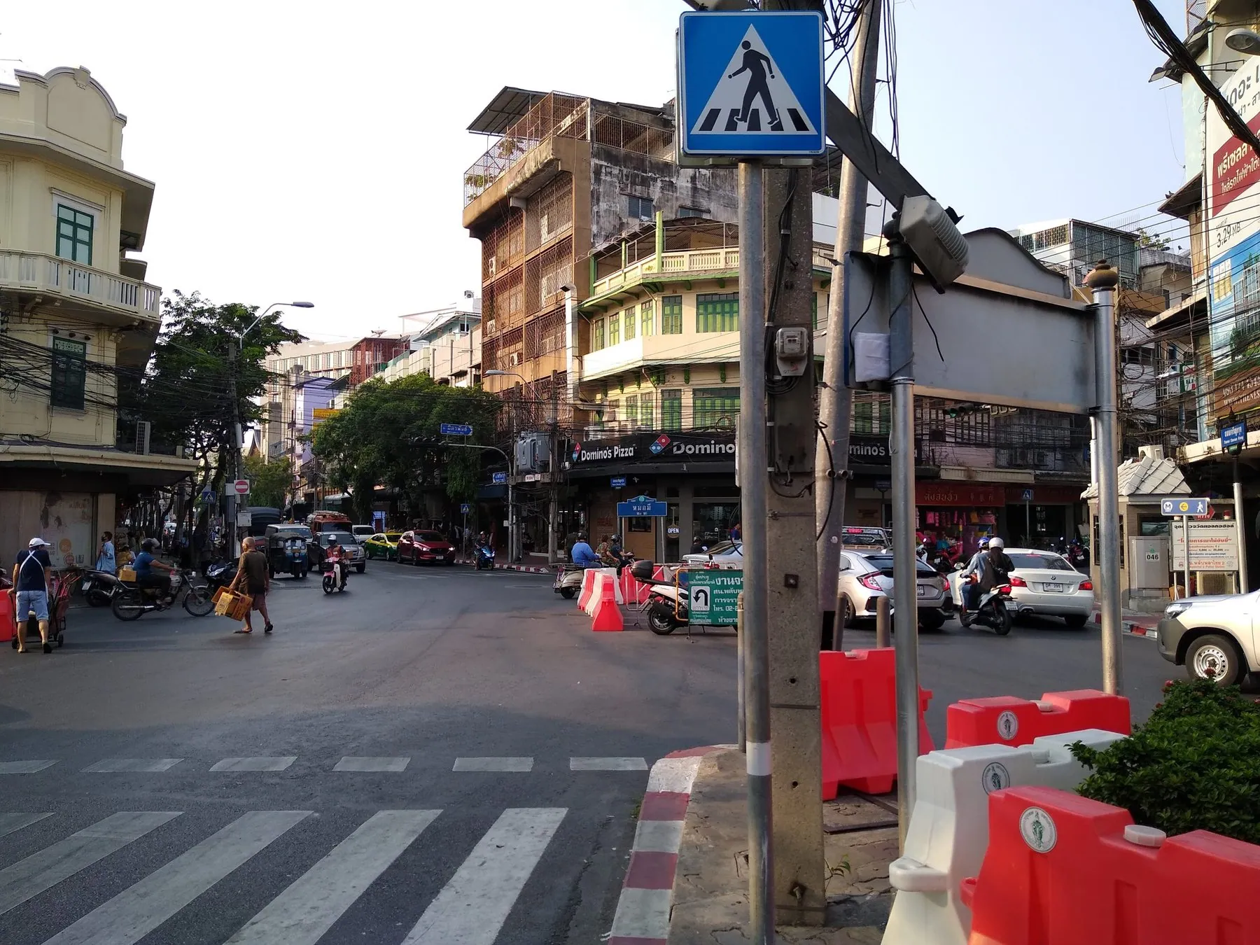 Cars and motorbikes crossing a wide Bangkok junction marked out with white lane lines