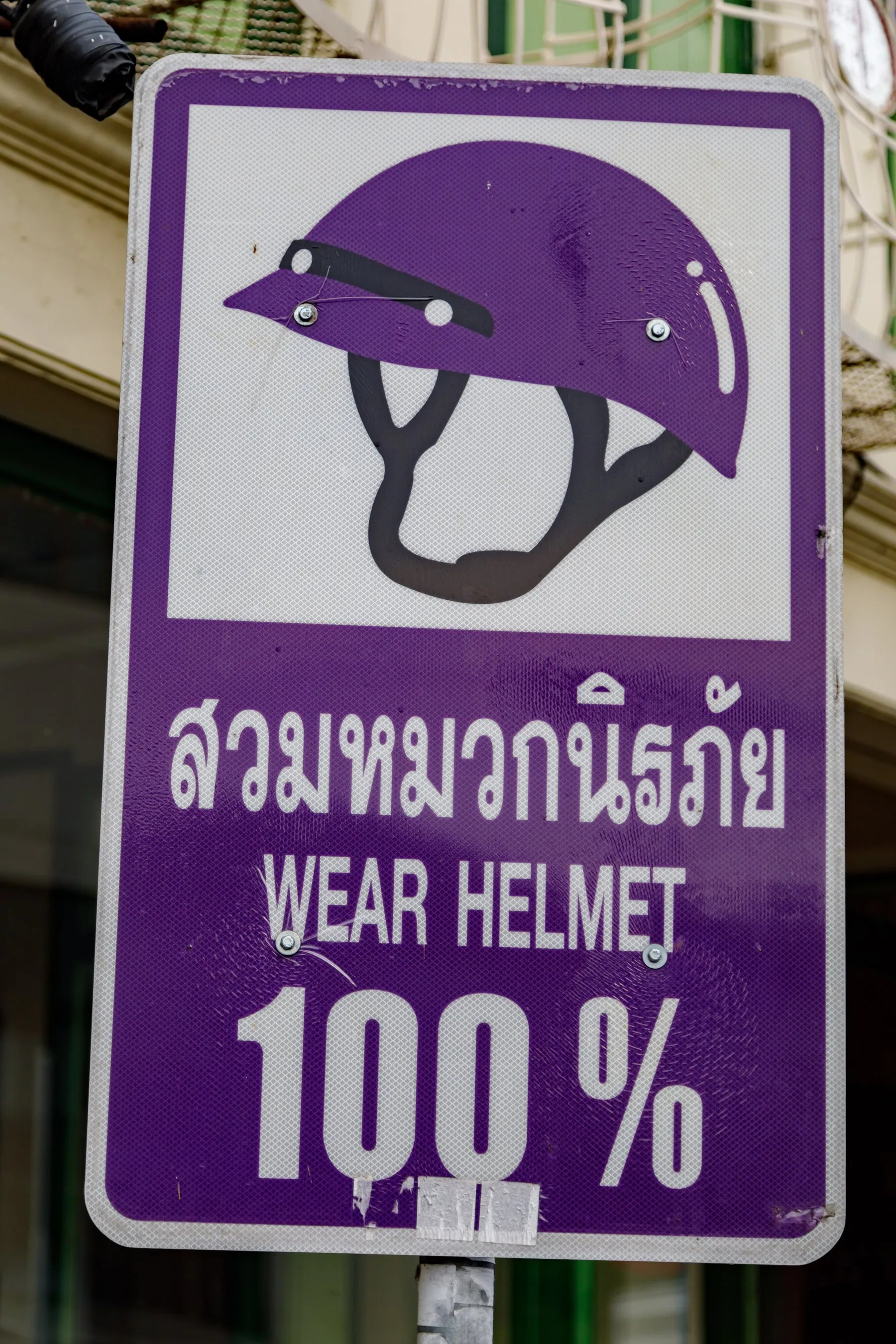 A blue Thai sign in Phuket province instructing riders to wear a helmet