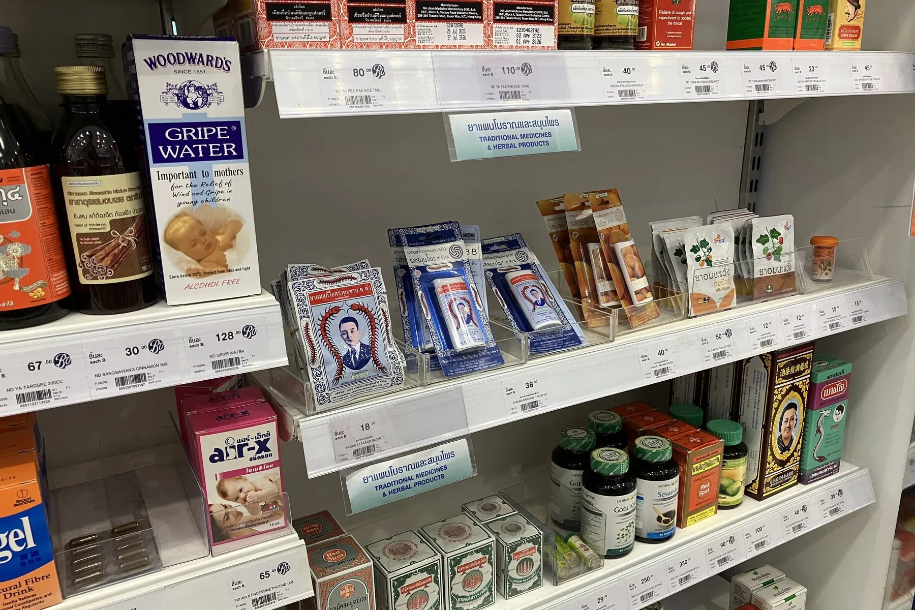 Boxes of Thai-labelled cough and cold medicine lined up on a drugstore shelf