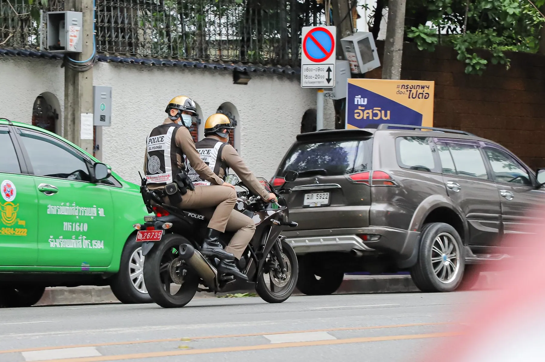 A Royal Thai Police motorcycle patrol pulled up at the kerb on a Bangkok street