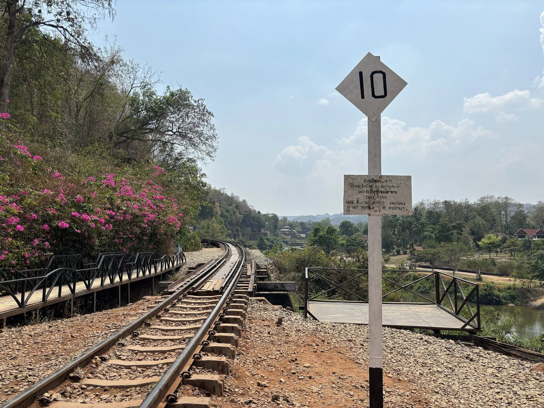 A circular red-bordered Thai speed-limit sign standing at the northern portal of the Tham Krasae bridge