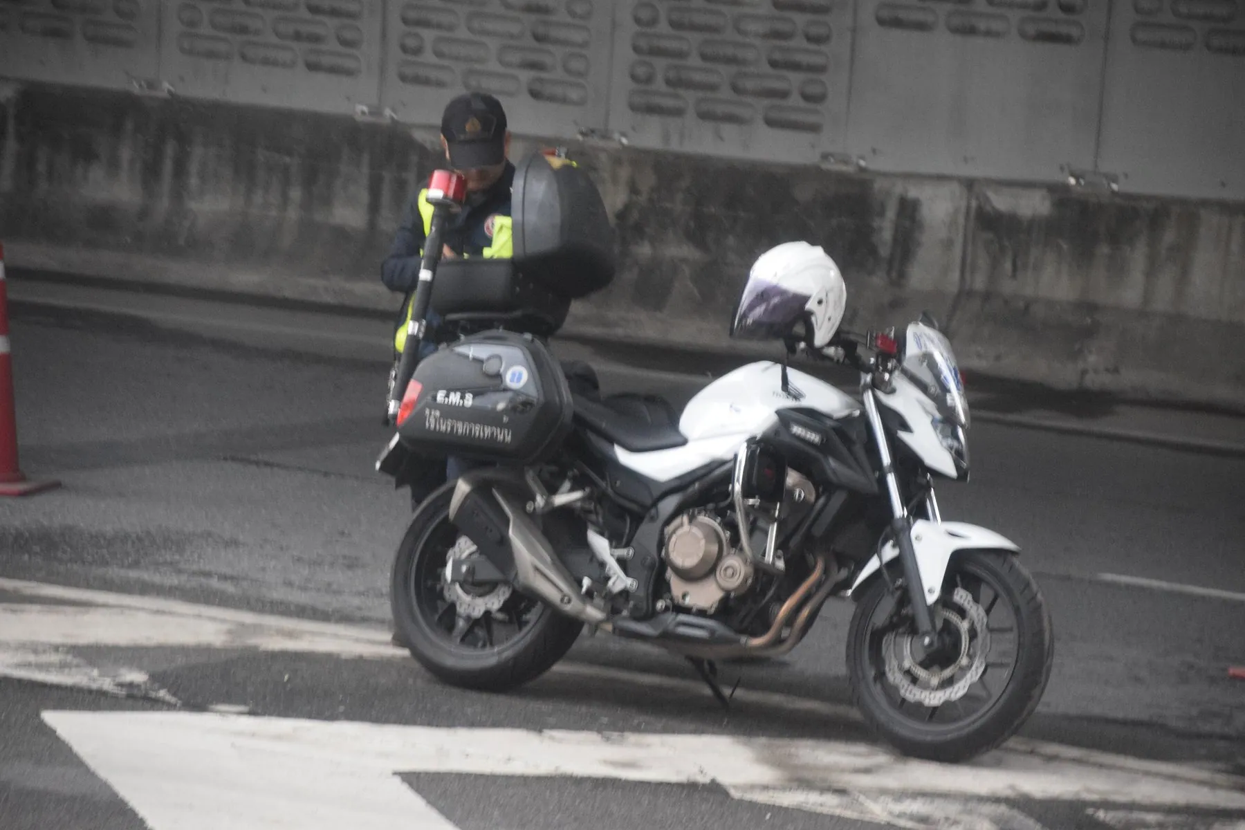 A Royal Thai Police motorcycle standing at the kerb with its panniers and radio fitted