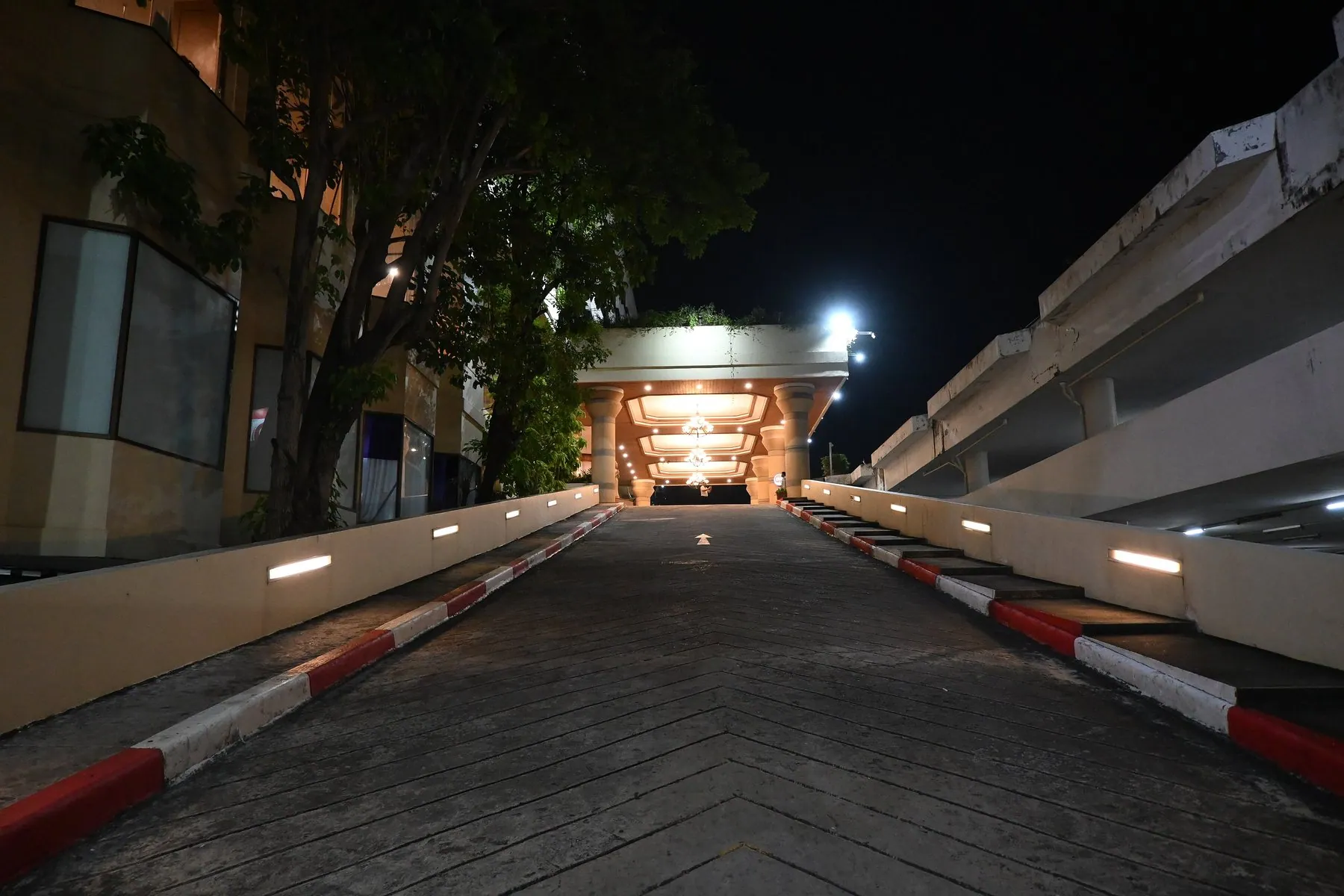 A driveway ramp in Thailand edged with kerbstones painted in alternating red and white bands