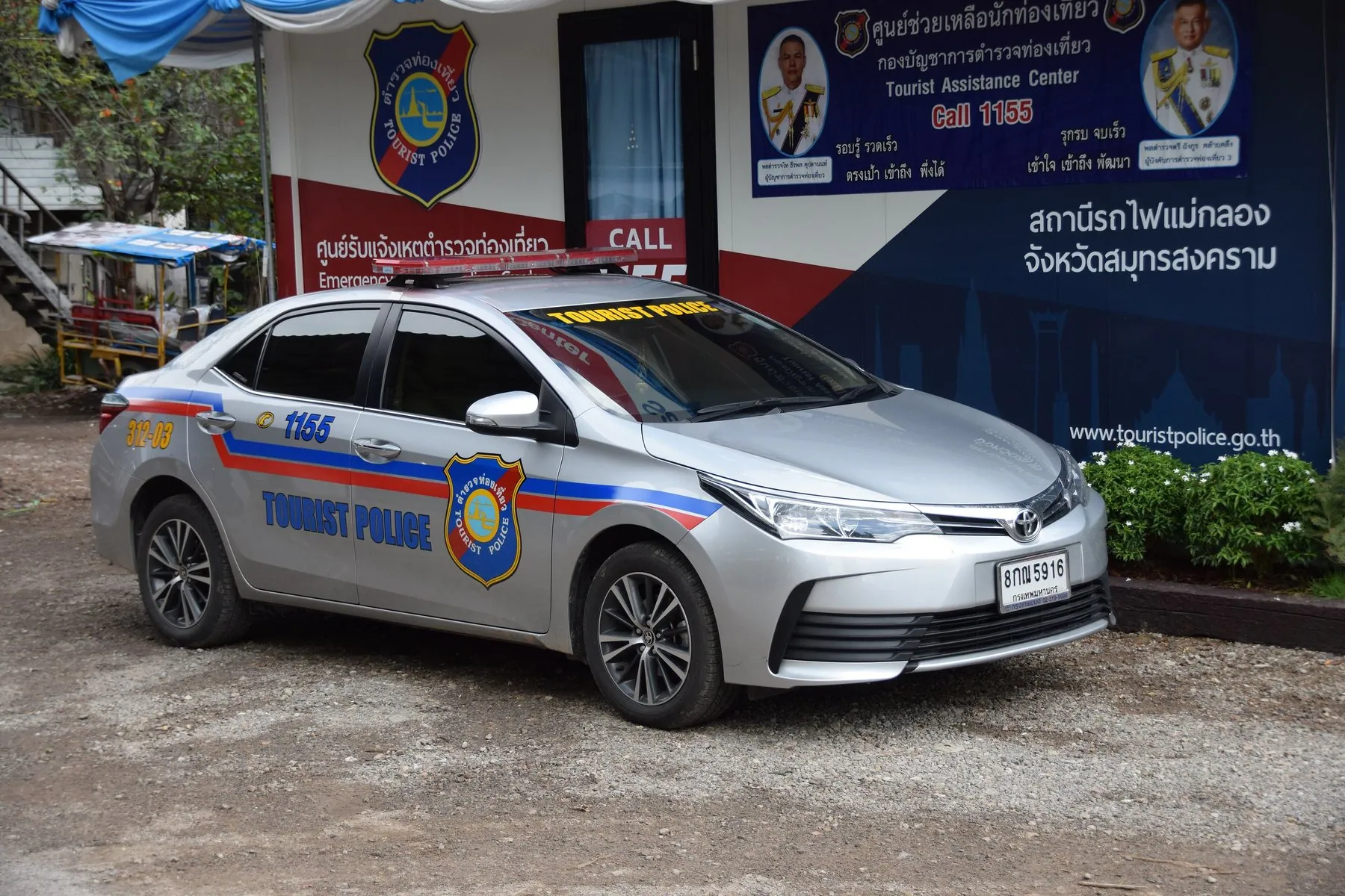 A Thai Tourist Police car in its distinctive livery parked beside a street
