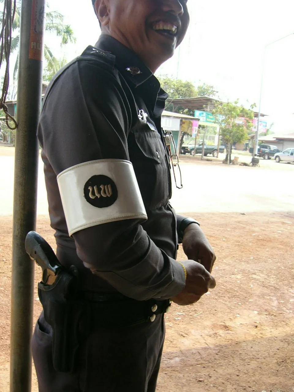 A Royal Thai Police officer on road traffic duty standing at the side of the carriageway