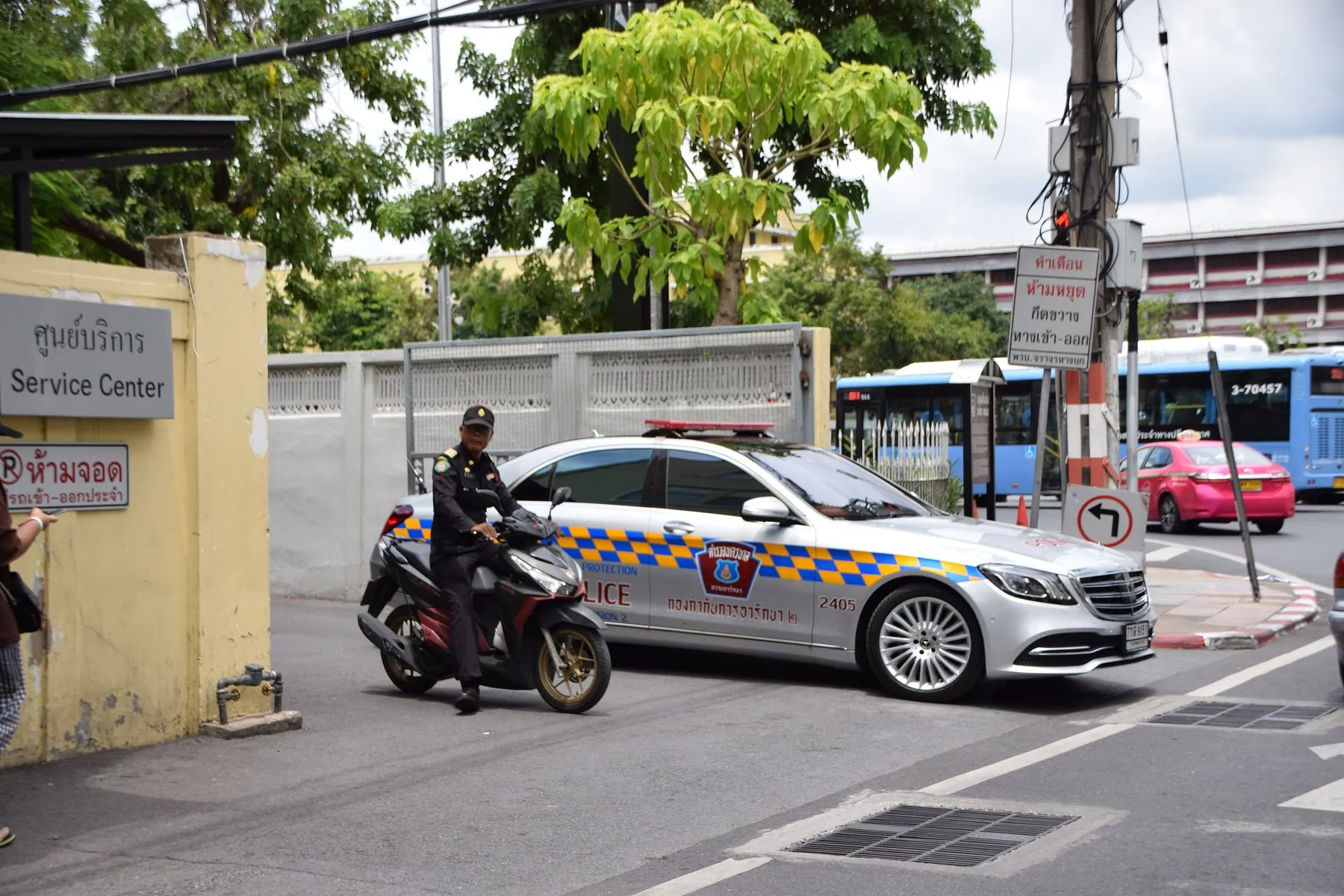 A Royal Thai Police patrol car in white and brown livery standing at a roadside in Thailand