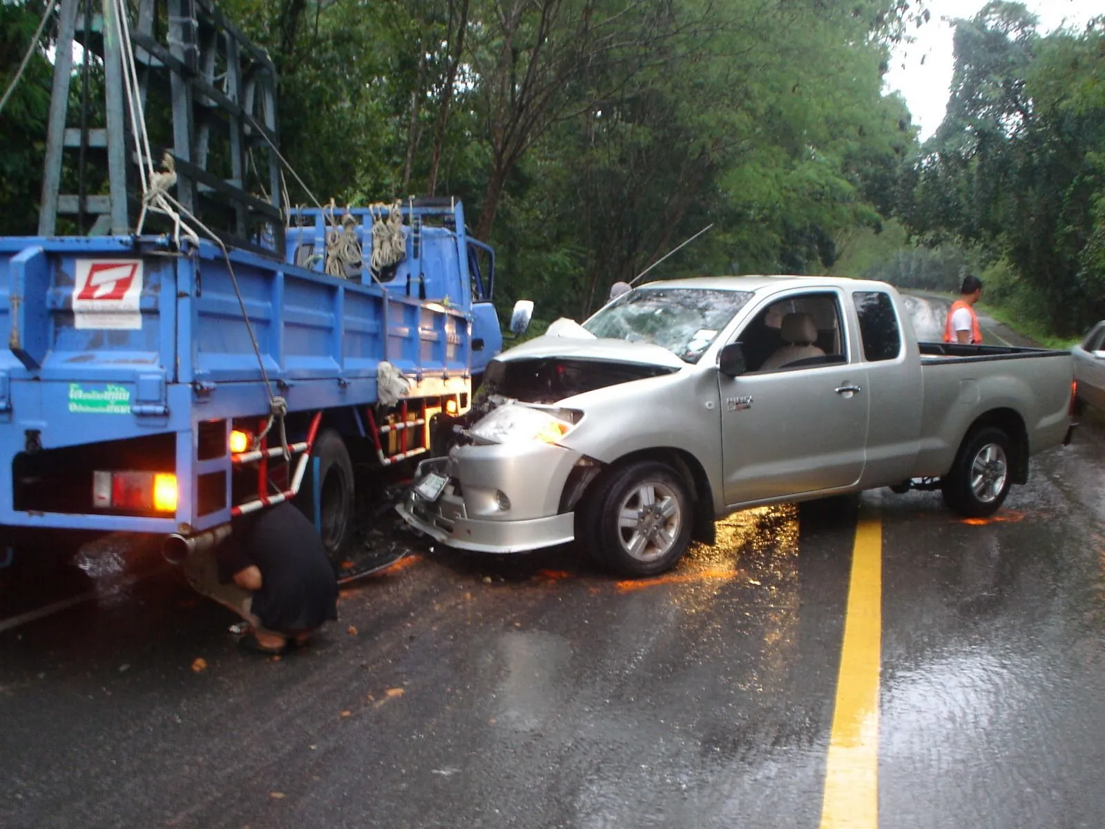 The same collision seen from behind the truck, the pickup's crushed front wing against the tail lift