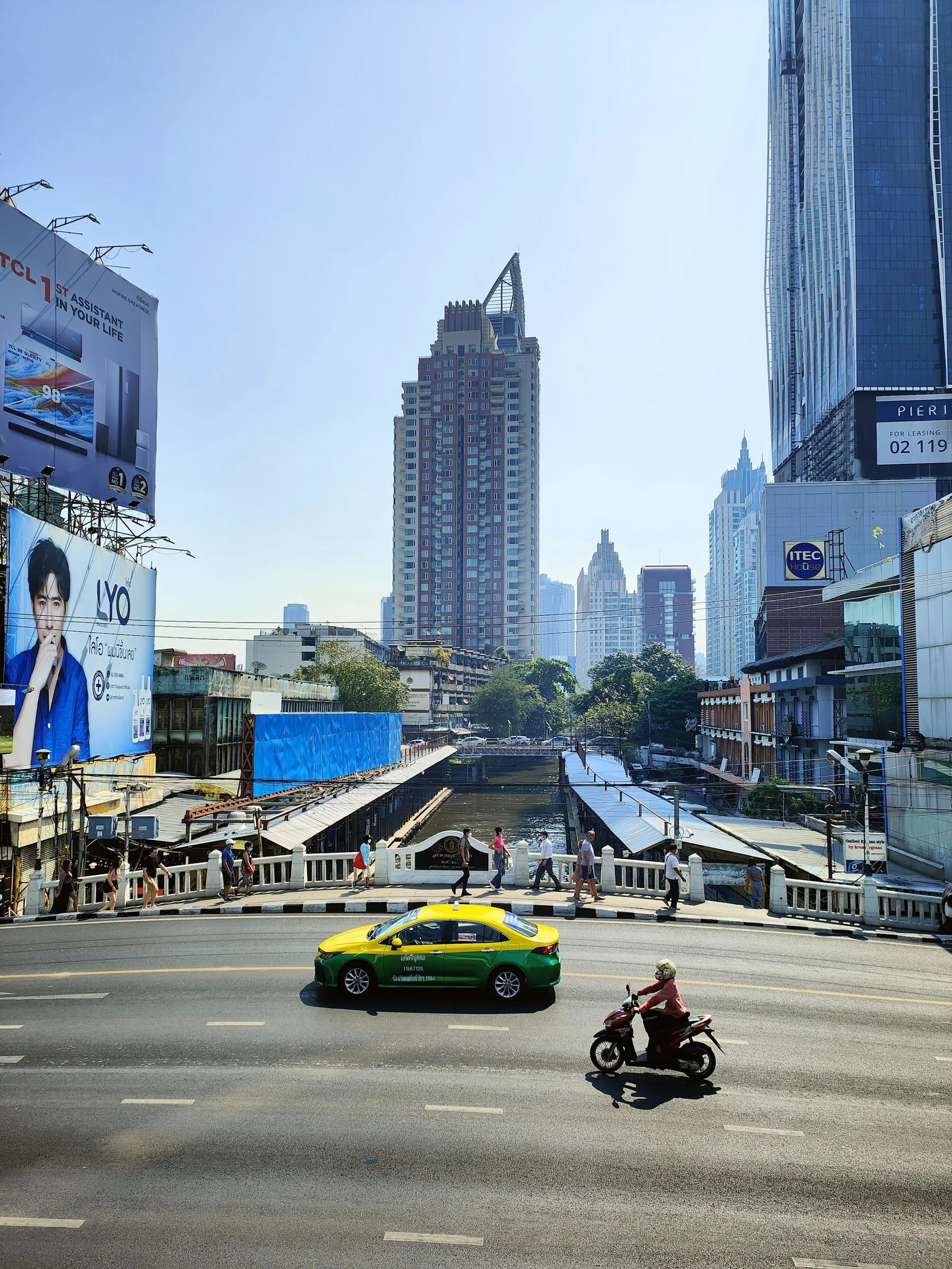 A green taxi and a lone motorbike sharing an empty elevated Bangkok expressway lane